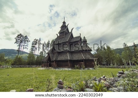 Urnes stavkirke at highland landscape photo. Beautiful nature scenery photography with cloudy sky on background. Idyllic scene. High quality picture for wallpaper, travel blog, magazine, article