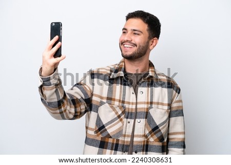 Young Brazilian man isolated on white background making a selfie