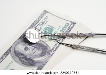 Expensive dentistry treatment concept. Dental tools and money on a white background, close-up.