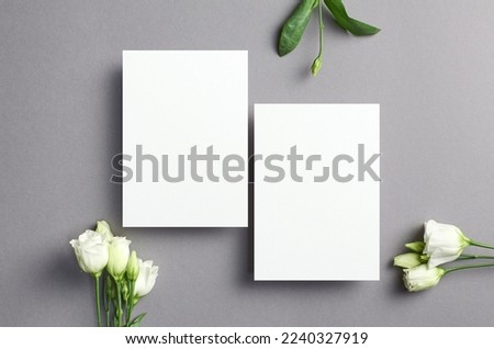 Wedding invitation card mockup with front and back sides and white flowers, top view with copy space