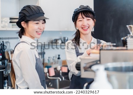 A woman working part-time in a restaurant happily learning about her duties Royalty-Free Stock Photo #2240329617