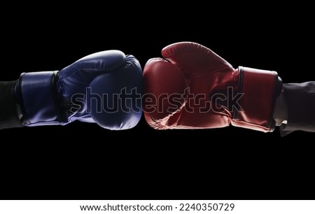 Two men's hands in boxing gloves. The concept of confrontation. Photo on a black background Royalty-Free Stock Photo #2240350729