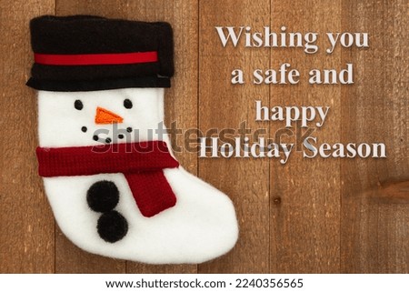 Wishing you a safe and happy Holiday Season with a snowman stocking on weathered wood
