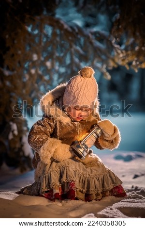 Little girl in the winter forest at night