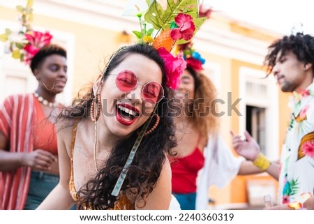 Cheerful brazilian woman laughing and dancing in the street. Brazil Carnaval festival and people in costume celebrating. Royalty-Free Stock Photo #2240360319