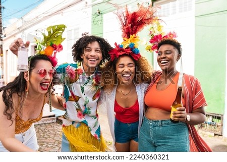 Group of people enjoying street Carnival festival. Friends laughing outdoors in costumes. Royalty-Free Stock Photo #2240360321