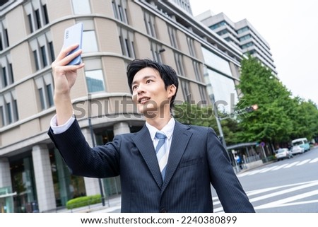Businessman using smartphone in business district