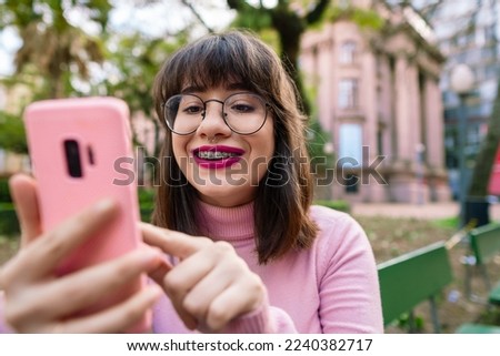 happy university student checking messages on smart phone in urban park