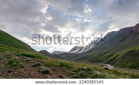 beautiful sunrise in the mountains. snowy mountain peaks under the sun. alpine meadows under snow-capped mountains Royalty-Free Stock Photo #2240385545