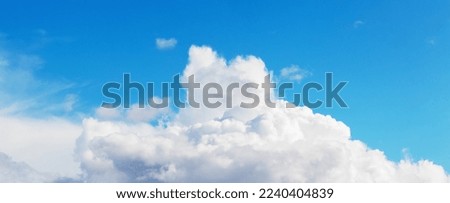 White curly clouds in the blue sky in sunny weather