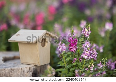 This picture is a birdhouse in flower garden.