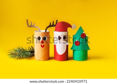 Christmas decoration for winter season. Holiday easy DIY craft idea for kids. Toilet paper roll tube toy. Santa snowman deer on yellow background. eco-friendly, reuse, recycle handmade minimal concept