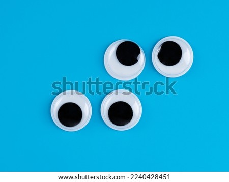 right offset pairs of  googly eyes funny Isolated on light blue  background copy space logo