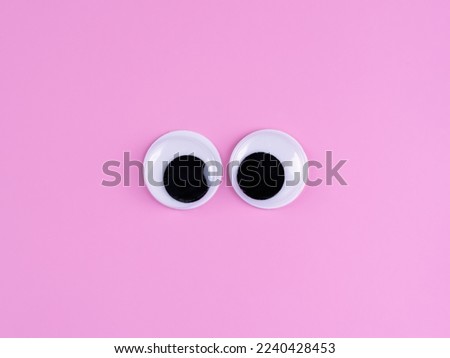 googly eyes funny cute Isolated on bright light pink background copy space logo