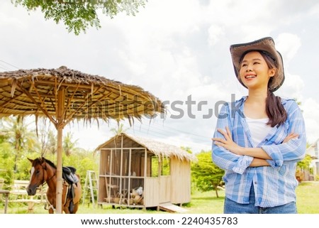 Smart businesswoman, farmer stand with their arms crossed to welcome tourists in front of a business farmhouse, cafe with horse farm and recreational activities : Farm cafe business concept