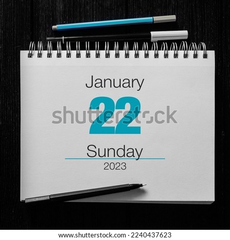 22th January. Notebook on a black wooden background 