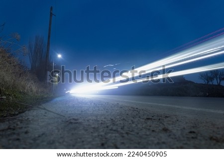 Light traces of passing cars at sunset. Long time exposure, motion blur effect.