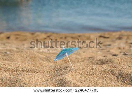 Small blue umbrella at the beach with copy space. Tourism concept.