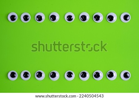 lime green background with two rows of googly eyes to form a frame