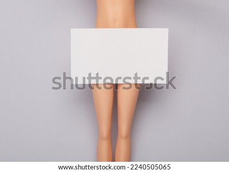 Doll with White Blank business card for corporate identity on gray background. Creative mockup