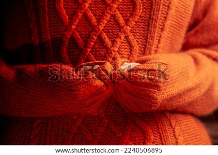 female hands in a warm sweater, heat theme