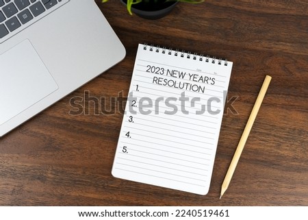 2023 New Year's resolutions text on note pad on top of office desk