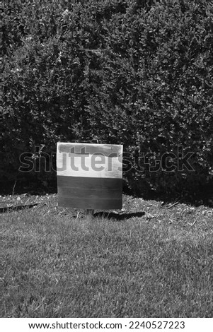 Typical yard sign standing on the front lawn in a black and white monochrome.