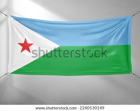 Djibouti national flag cloth fabric waving on beautiful grey sky.