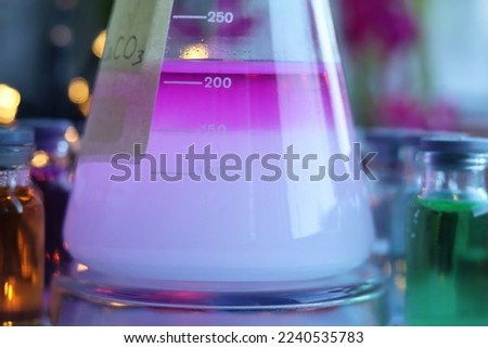 The process of layering between substances, in the lower layer a white colloidal precipitate of calcium carbonate, in the upper layer the indicator dye phenolphthalein. Royalty-Free Stock Photo #2240535783