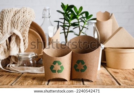 The concept of recycling and biodegradable materials. Eco-friendly paper containers for fast food with a recycling sign.
