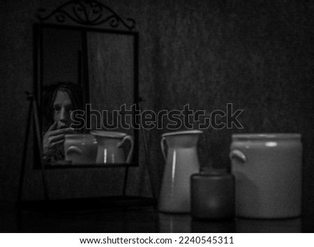 Portrait of man in old mirror with dark black and white vintage background
artistic noise
