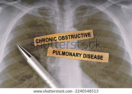 Medical concept. On a human chest x-ray, a pen and strips of paper labeled - CHRONIC OBSTRUCTIVE PULMONARY DISEASE Royalty-Free Stock Photo #2240548513
