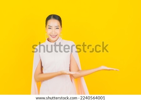 Portrait beautiful young asian woman smile with many action on yellow background