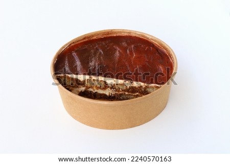 Tiramisu cake made and cut on paper bowl isolated on white background