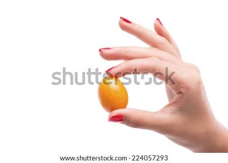 Woman with nice red polished nails showing us the size of little yellow fruit in her hands. Isolated on white background