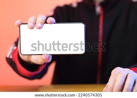 smartphone in the hand with a white screen in the hand of the person in the background