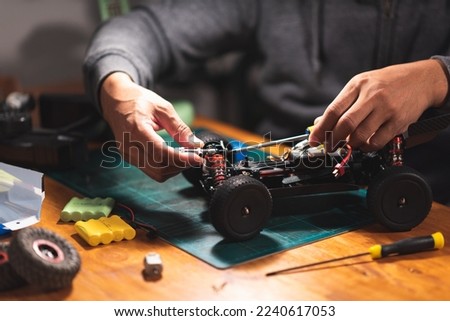 The man working on radio controlled buggy car. RC car assembly scene. Royalty-Free Stock Photo #2240617053