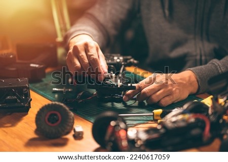 The man working on radio controlled buggy car. RC car assembly scene. Royalty-Free Stock Photo #2240617059
