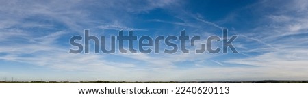 Blue-white cloud background with cirrostratus clouds and contrails Royalty-Free Stock Photo #2240620113