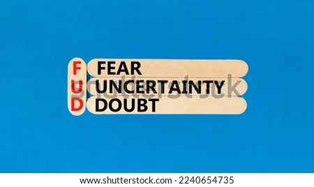 FUD fear uncertainty doubt symbol. Concept words FUD fear uncertainty doubt on wooden sticks on a beautiful blue table blue background. Business and FUD fear uncertainty doubt concept. Copy space.