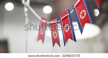 A garland of North Korea national flags on an abstract blurred background