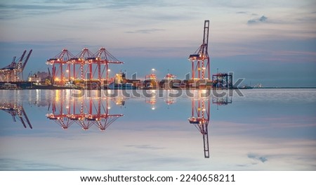 Container terminal in industrial port with cranes - Ship loading in port with busy port at night - Mersin, Turkey Royalty-Free Stock Photo #2240658211
