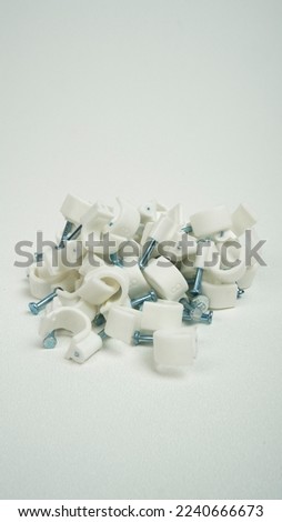 Clamp nails are piled messy in the middle with a white background
