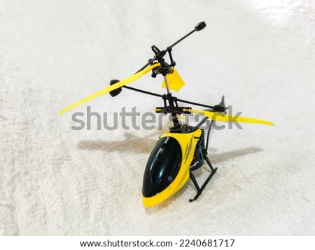 black and yellow helicopter toy on the white background