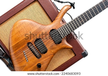 An electric guitar and a vintage looking combo amp shot against a white background.