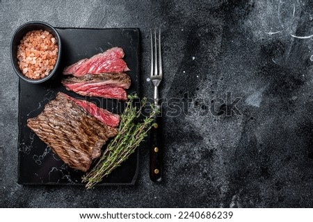 Grilled Wild Venison steak with thyme and salt, game meat. Black background. Top view. Copy space. Royalty-Free Stock Photo #2240686239