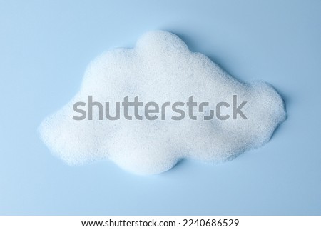 Foam sample in shape of cloud on light blue background, top view Royalty-Free Stock Photo #2240686529
