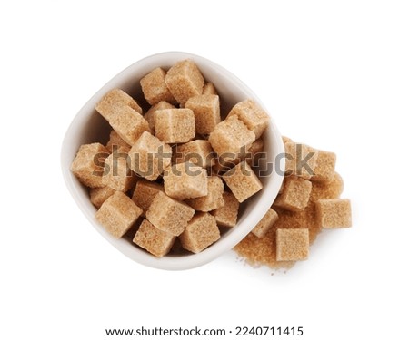 Bowl and brown sugar cubes on white background, top view Royalty-Free Stock Photo #2240711415
