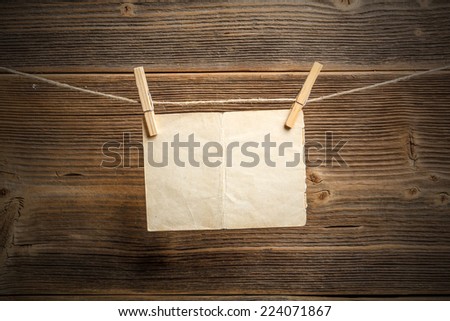 Paper attach to rope with clothes pins on wooden background 