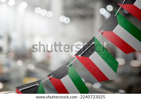 A garland of Kuwait national flags on an abstract blurred background